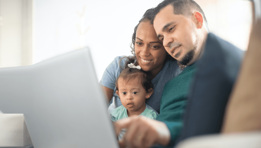 Family with child looking at laptop screen